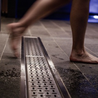 Rostfri golvränna i ett badhus